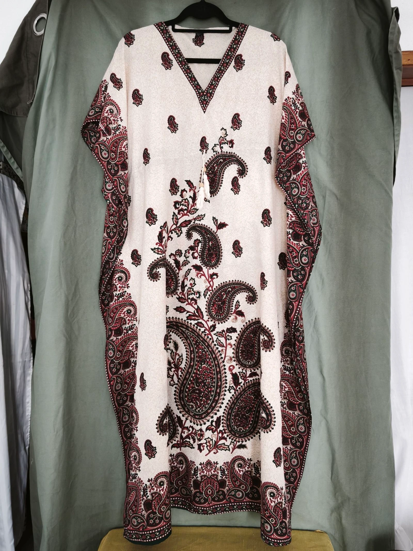 Kaftan com um elegante padrão paisley em tons de bege e vermelho.